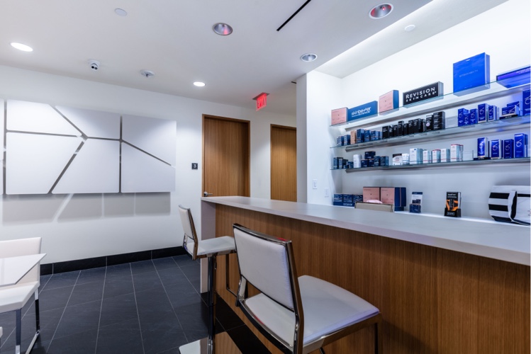 an image of one of the waiting areas showcasing skin care products on the wall