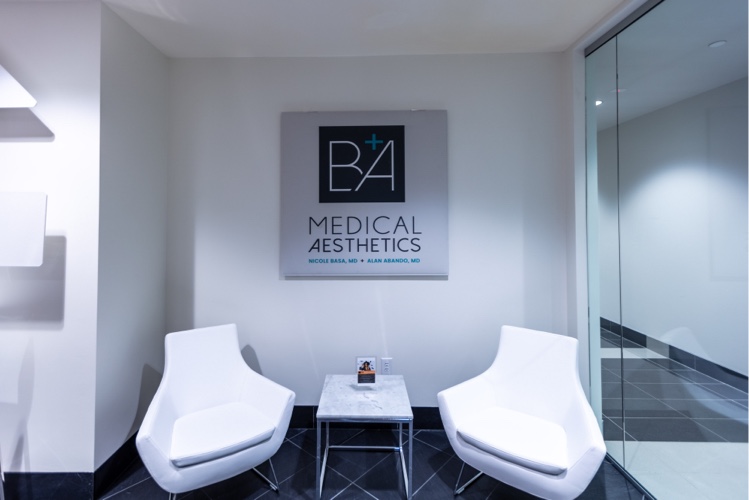 an image of the lobby with two white chairs before the B + A Medical Aesthetics sign